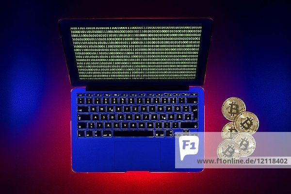 Symbol Bild digitale Währung  goldene physische Münze bitcoin Laptop mit digitalen binären Code
