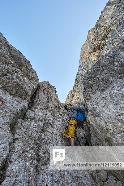 Hiker climbing in the Santner via ferrata  Rosengarten Group  Dolomites  South Tyrol  Trentino-Alto Adige  Italy  Europe