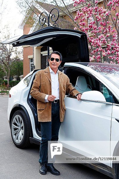 The old man leans over the car
