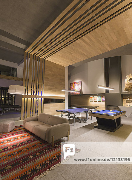 Beleuchtetes  modernes  luxuriöses Haus mit einem Spielzimmer mit Billardtisch und Tischtennisplatte
