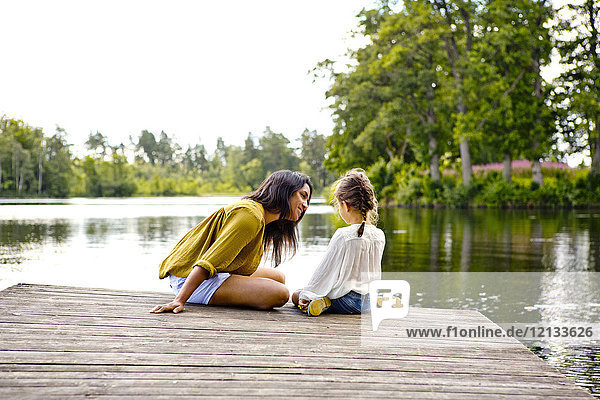 Mutter und Tochter am Pier am See in Friseboda Schweden