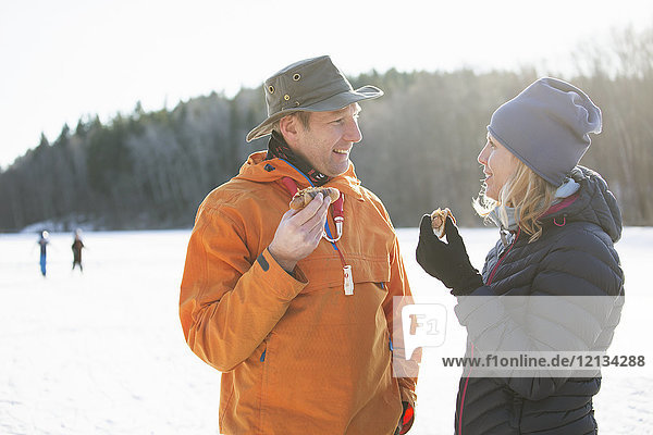 Paar essen Würstchen im Winter in Akersberga, Schweden