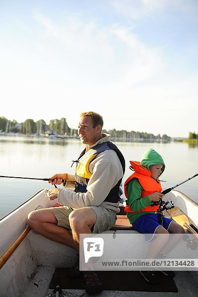 Father and son fishing off a boat in Tunaviken Osterskar  Sweden