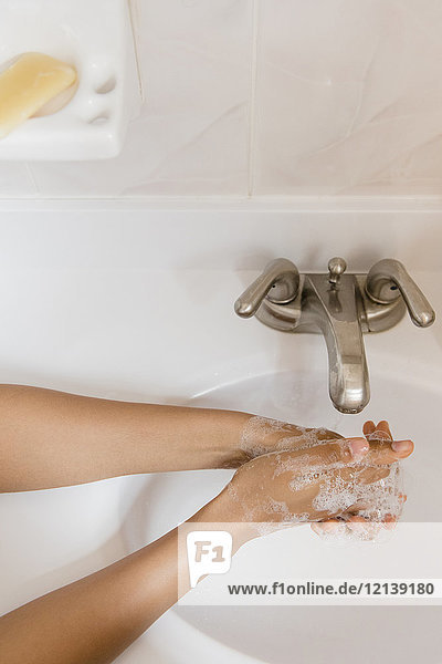 Afroamerikanische Frau wäscht sich die Hände mit Seife