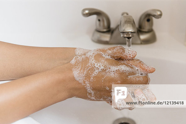 Afroamerikanische Frau wäscht sich die Hände mit Seife