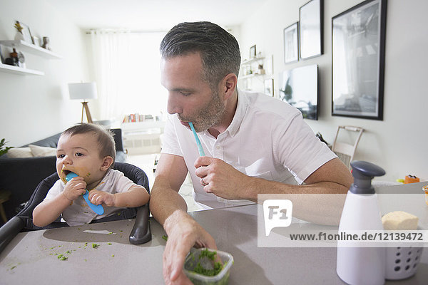 Vater beobachtet seinen kleinen Sohn beim Essen