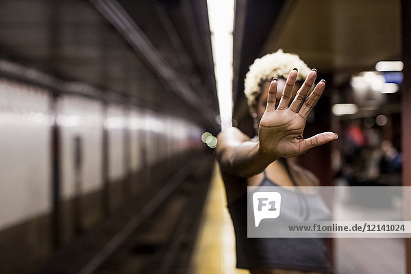 USA  New York City  woman on subway station platform showing hand palm