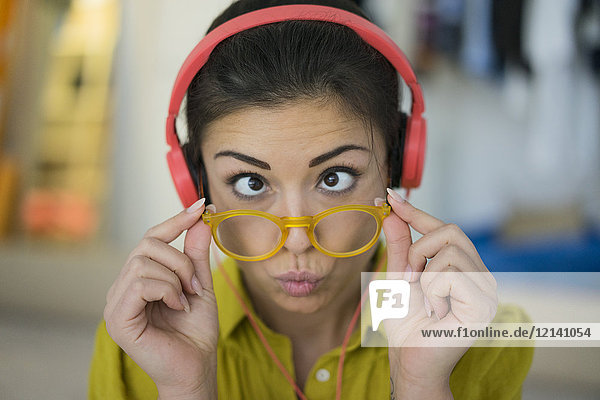 Porträt einer Frau mit Kopfhörer und Brille mit lustigem Gesicht