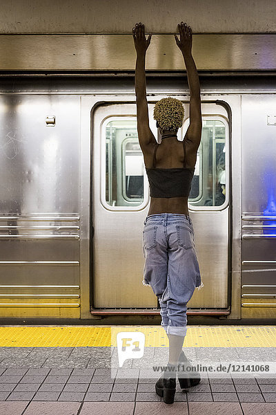 USA  New York City  back view of woman standing on subway station platform