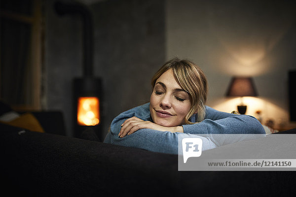Porträt einer Frau  die sich abends zu Hause auf der Couch ausruht