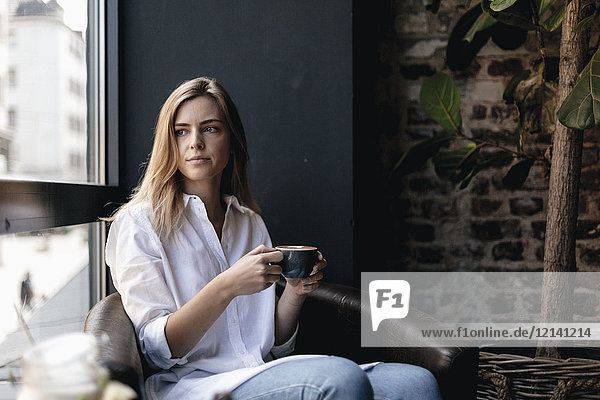 Young woman sitting in cafe  drinking coffee