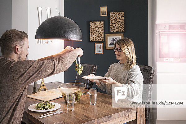 Couple eating salad at dining table at home
