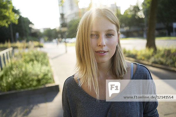 Portrait of blond young woman at backlight