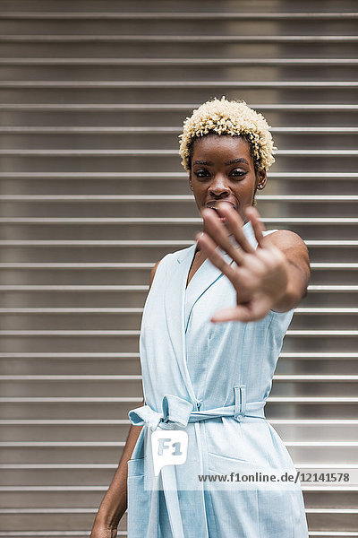 USA  New York  junge blonde Afroamerikanerin  hält Hand vor dem Gesicht