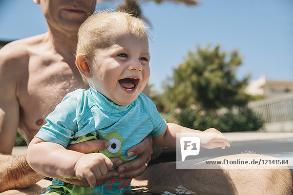 Baby genießt das Schwimmbad in den Sommerferien