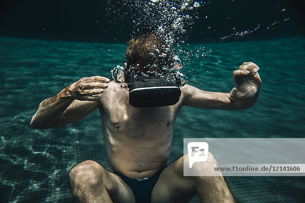 Mann unter Wasser im Schwimmbad mit VR-Brille