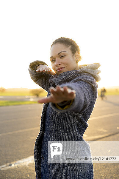 Portrait of smiling young woman outdoors at sunset