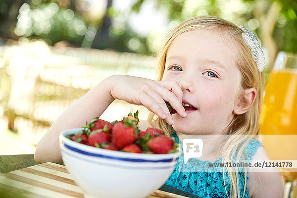 Portrait of girl eating stawberries