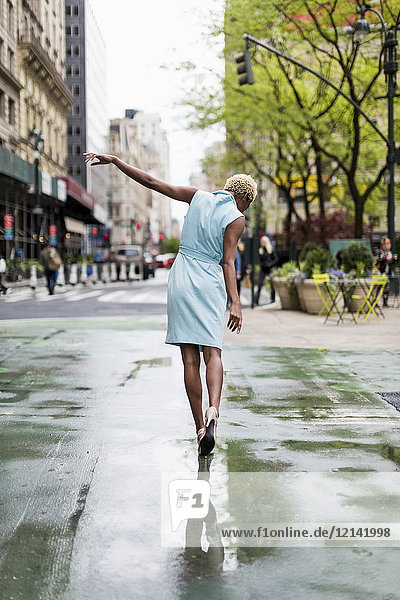USA  New York  young blonde african-american woman walking in puddle
