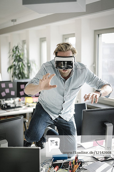 Geschäftsmann mit VR-Brille im Büro  der vorgibt  ein Löwe zu sein.