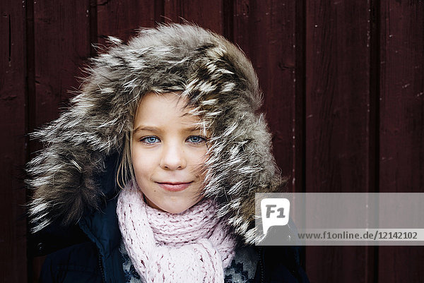 Porträt eines kleinen Mädchens mit windgepeitschter Fellkapuze