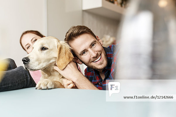 Happy young couple with dog at home