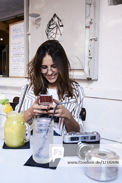 Young woman sitting in a coffee shop using smartphone