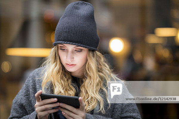 Porträt einer ernsthaften jungen Frau mit Smartphone