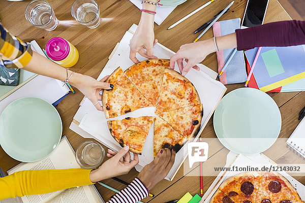 Group of young women at home sharing a pizza