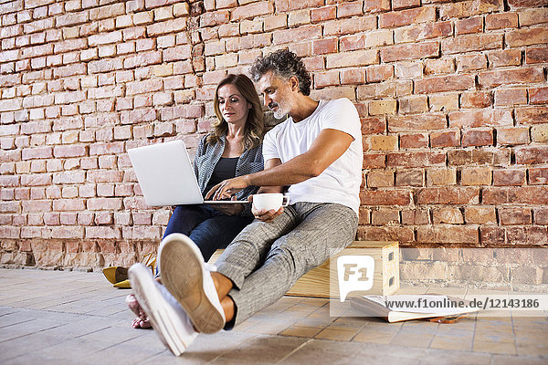 Businessman and woman sitting in a loft  using laptop  founding a start-up company