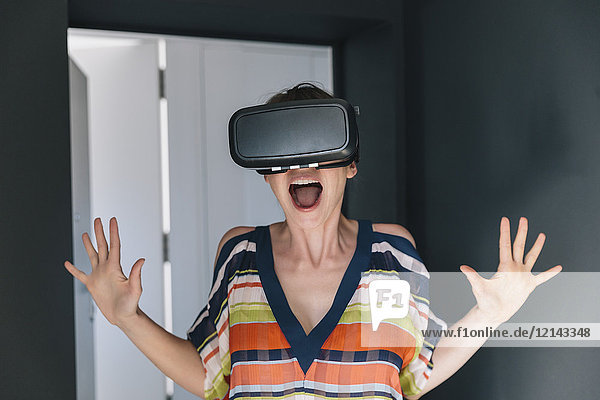 Erstaunte Frau mit VR-Brille macht ein verrücktes Gesicht
