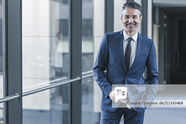 Portrait of smiling businessman on office floor