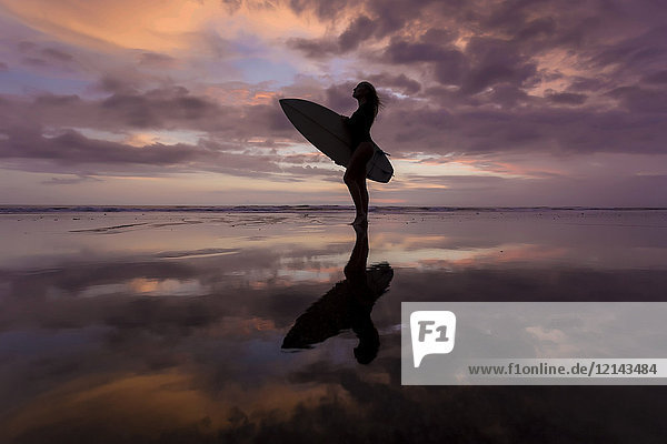 Indonesien  Bali  Junge Frau mit Surfbrett