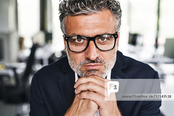 Portrait of serious mature businessman wearing glasses in office