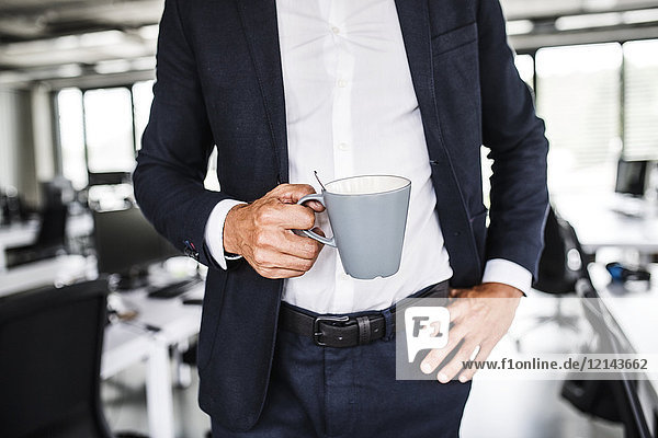 Nahaufnahme eines Geschäftsmannes mit Kaffeetasse im Büro