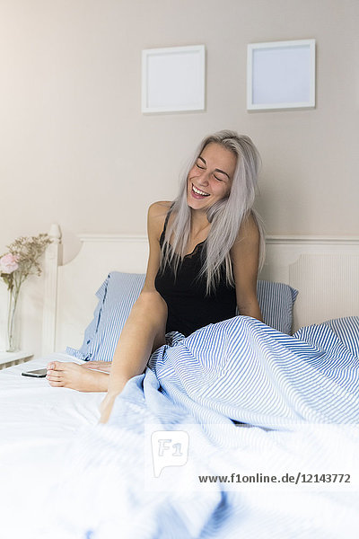 Happy young woman in bed