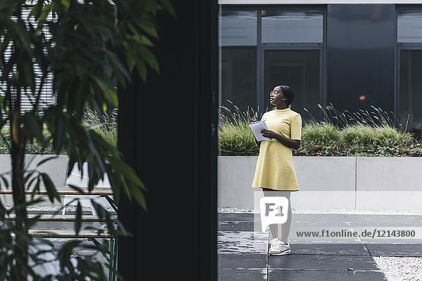 Businesswoman standing outside the office holding notebook