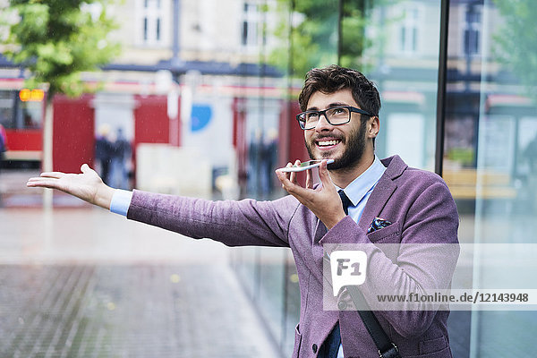 Porträt eines jungen Geschäftsmannes am Telefon an einem regnerischen Tag