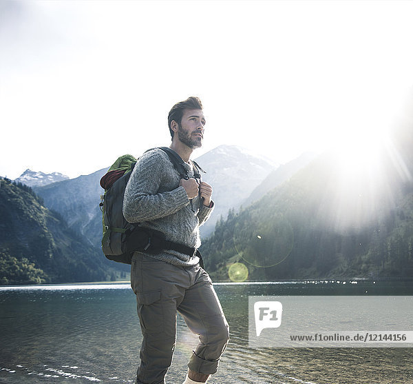Austria  Tyrol  young man hiking at mountain lake