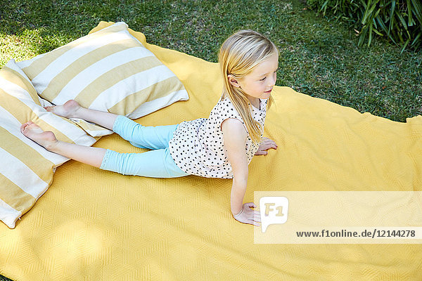 Girl practicing yoga on a blanket