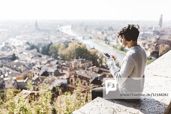 Italien  Verona  Touristen mit Smartphone  Kopfhörer
