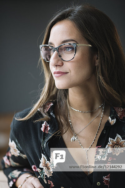 Porträt einer modischen Frau mit Brille und Nasenpiercing