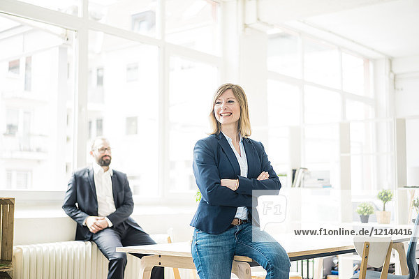 Smiling businesswoman and man in office