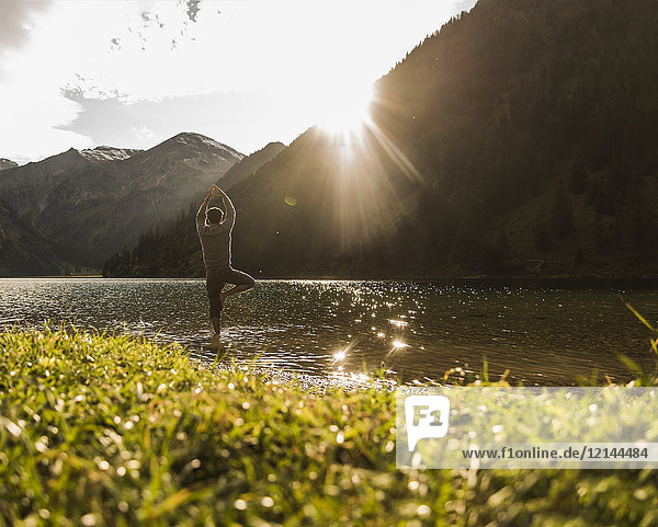 Österreich,  Tirol,  Wanderer in Yoga-Pose erfrischend im Bergsee