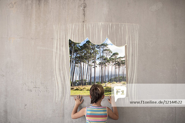 Mädchen hält ein Bild eines Waldes auf einer Betonwand mit einer Kreidegrenze