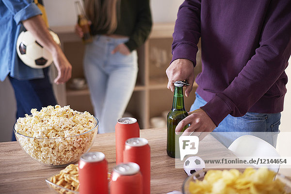 Fußballfan beim Öffnen einer Flasche Bier