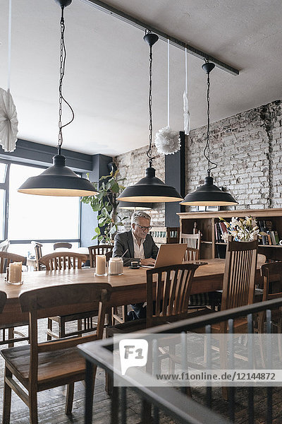 Geschäftsmann sitzend im Café  mit Laptop