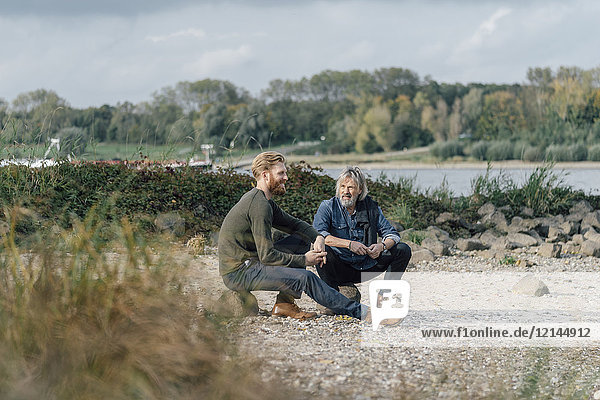 Vater und Sohn treffen sich im Herbst am Rhein  um miteinander zu reden.