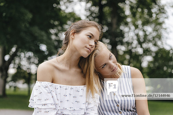 Young woman resting on female friend's shoulder