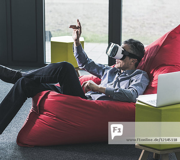 Man sitting in beanbag wearing VR glasses